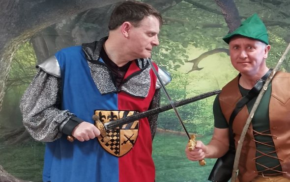 Two performers in Robin Hood pantomime costumes