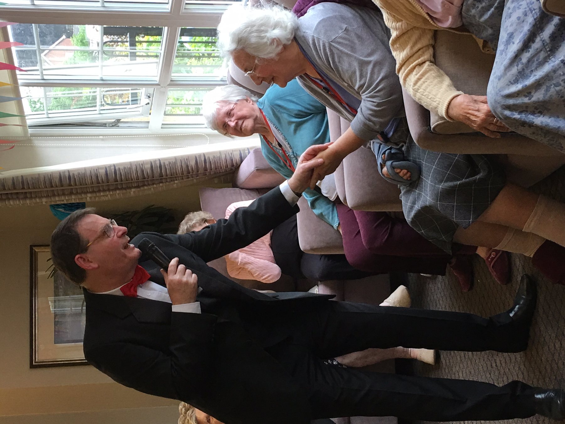 Entertainer speaking directly with care home residents